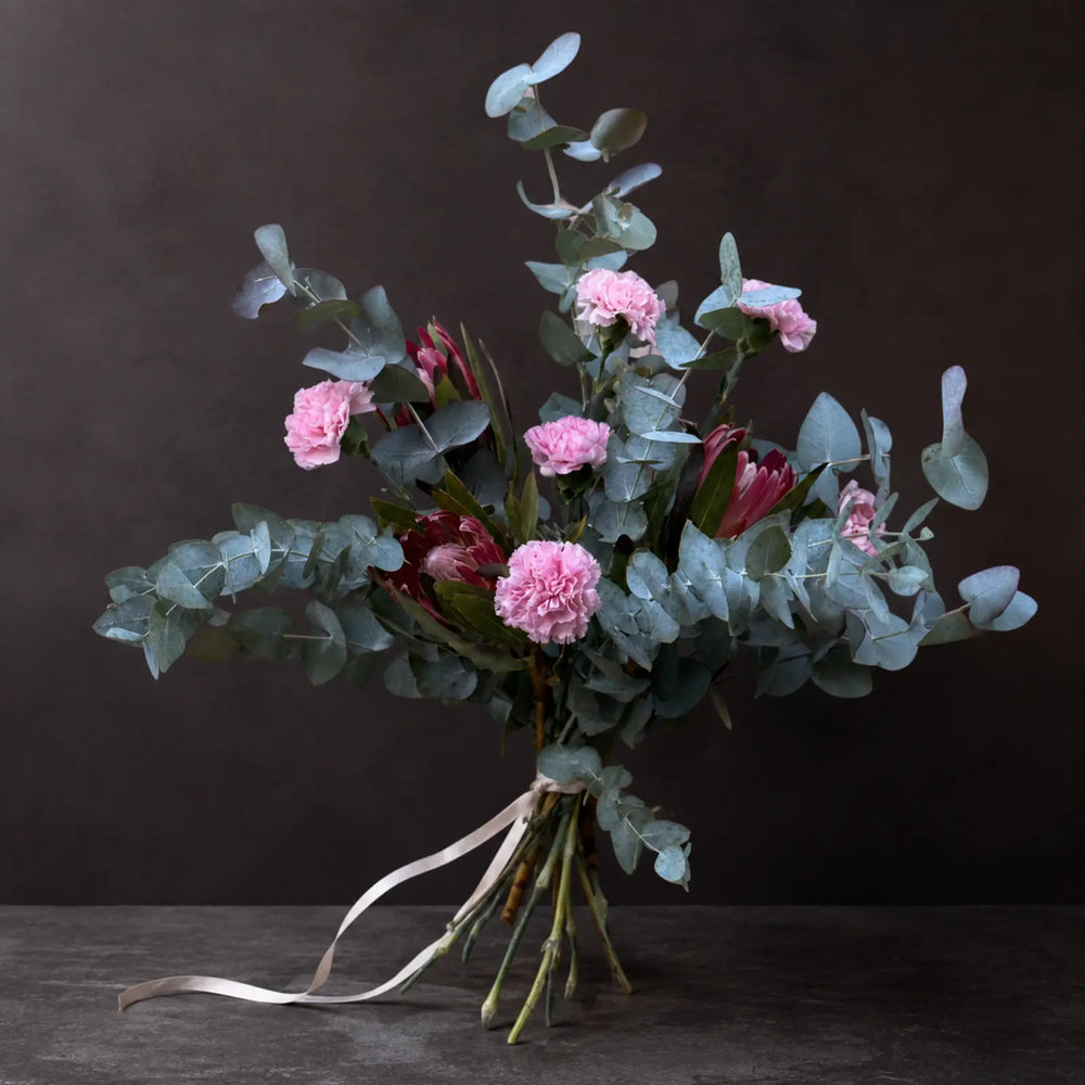 Nordisk Rose – luftig Florén buket med eukalyptus, rosa nelliker og protea