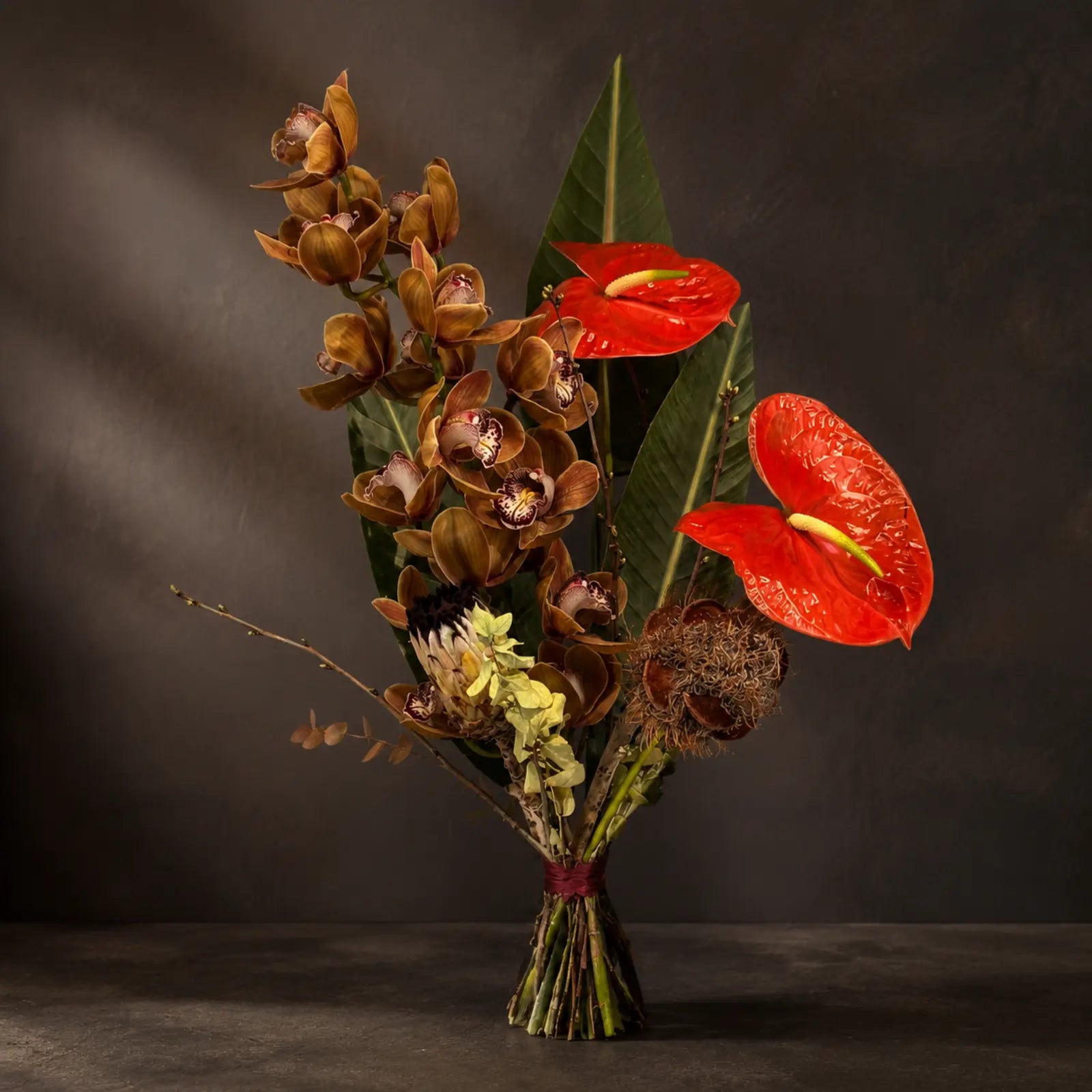 Ember Orchid – skulpturel buket med orkidéer og røde anthurium