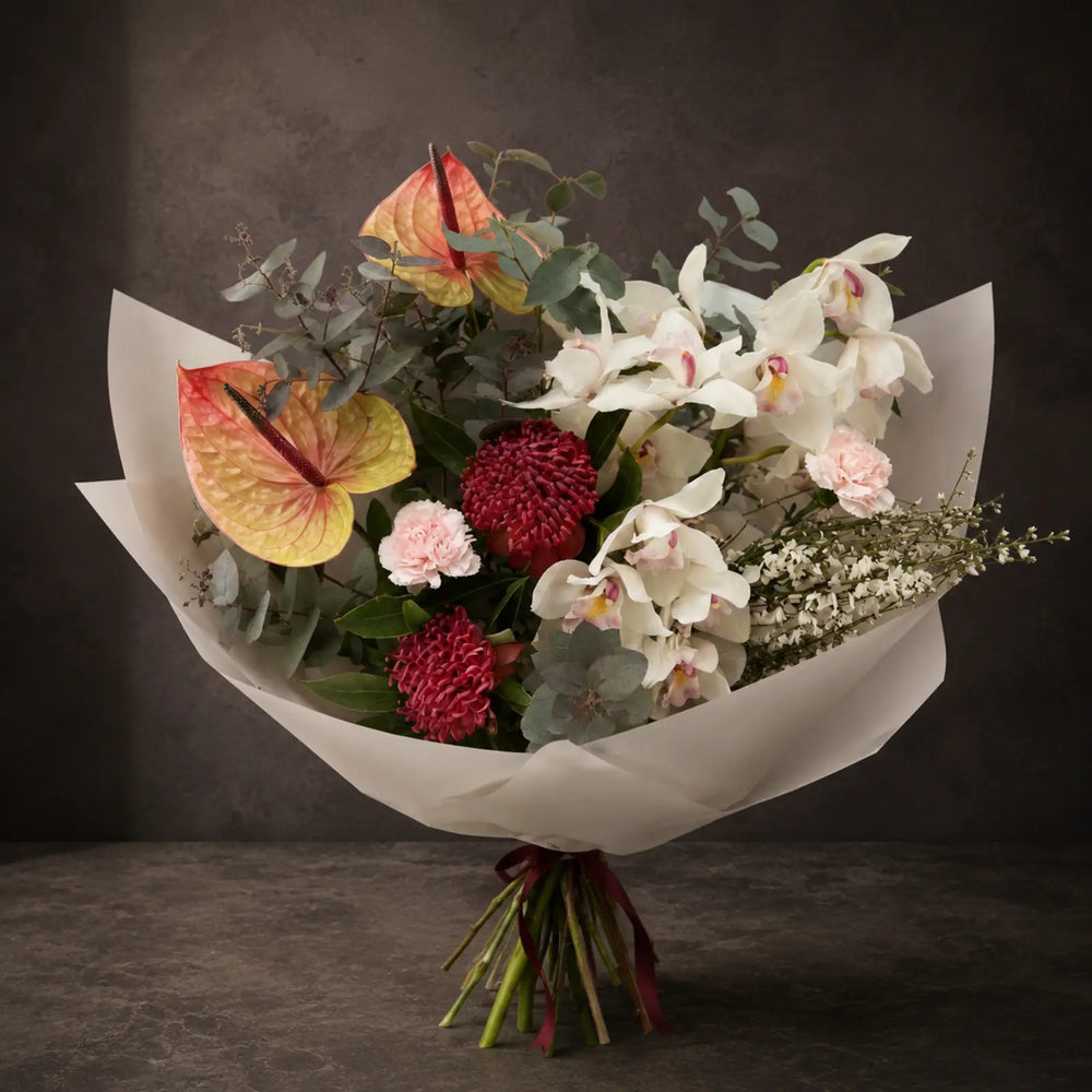 Porcelain Flame – luksusbuket med hvide orkidéer, anthurium og pink fokusblomster