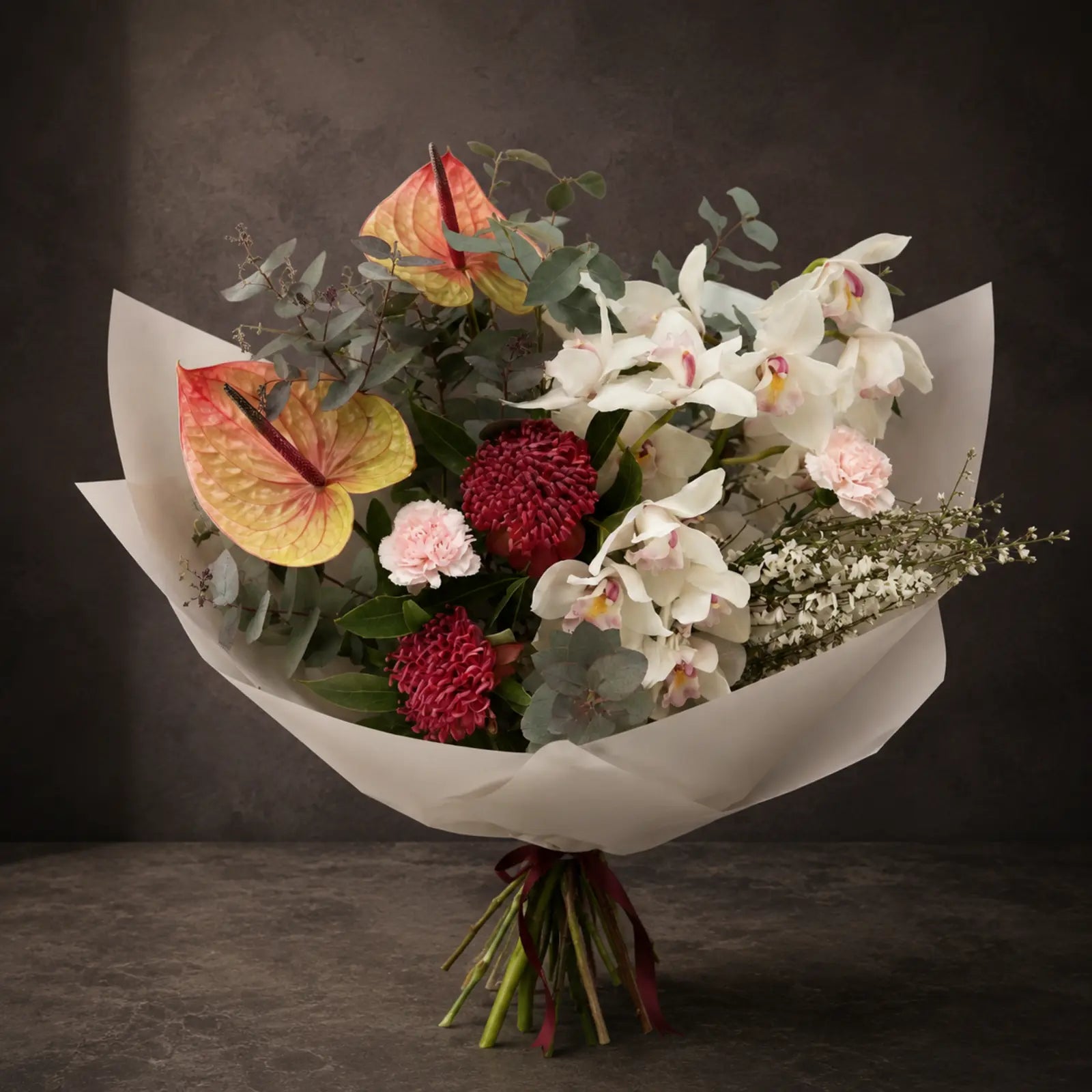 Porcelain Flame – luksusbuket med hvide orkidéer, anthurium og pink fokusblomster